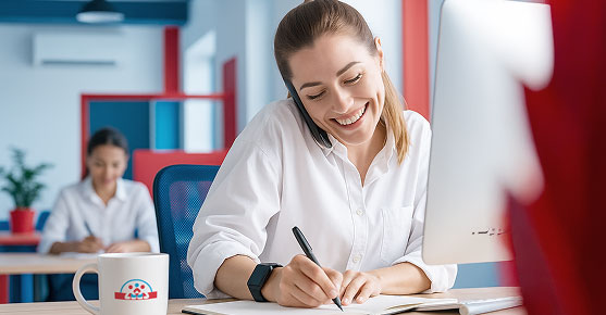 Eine Servicemitarbeiterin telefoniert und bearbeitet einen Auftrag